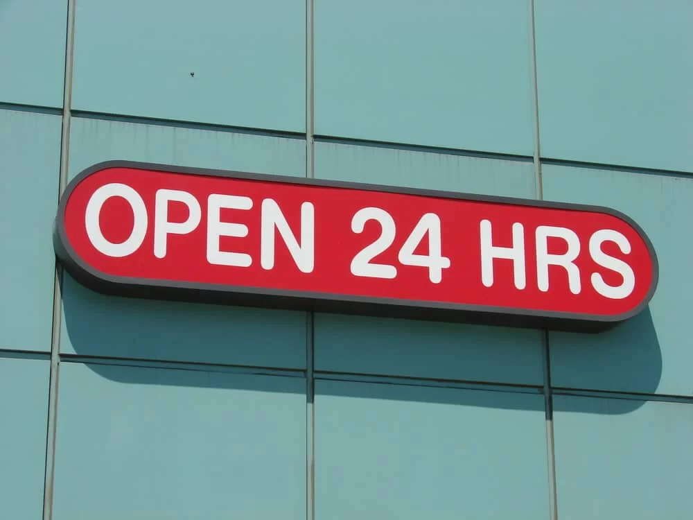 "Open 24 Hours" sign on the outside of a store