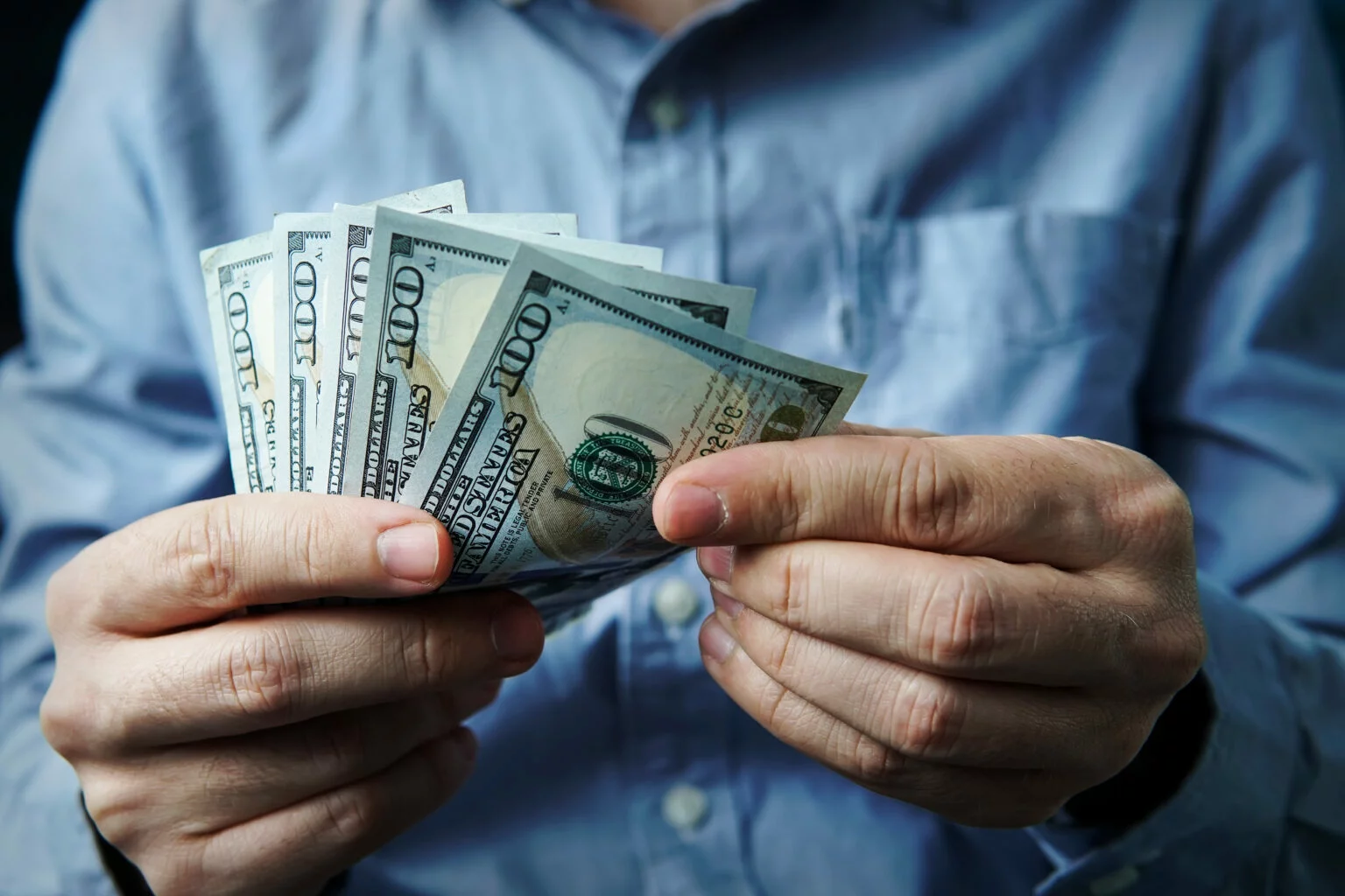 Close-up of man's hands counting cash after cashing a 401(k) check