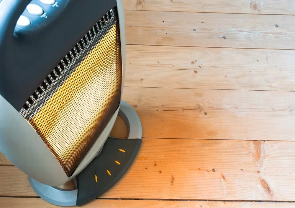 An infrared heater sitting on a light wood floor