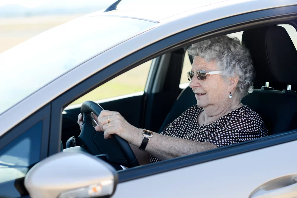Elderly woman driving a rental car