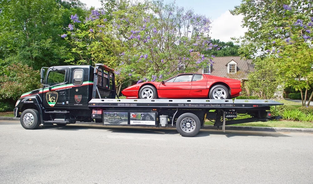 Sports car on a flatbed tow truck during repossession