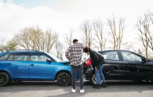 People inspecting their cars after a rear-ending accident