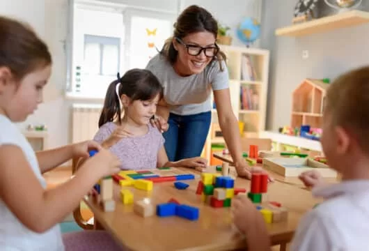 Woman teaching young children at a school like Everbrook Academy