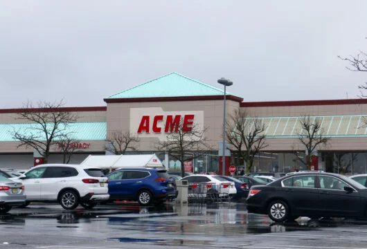 Exterior of an ACME Markets store and busy parking lot