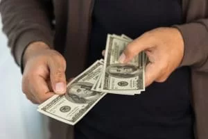 Close-up of man's hands holding cash after cashing a check