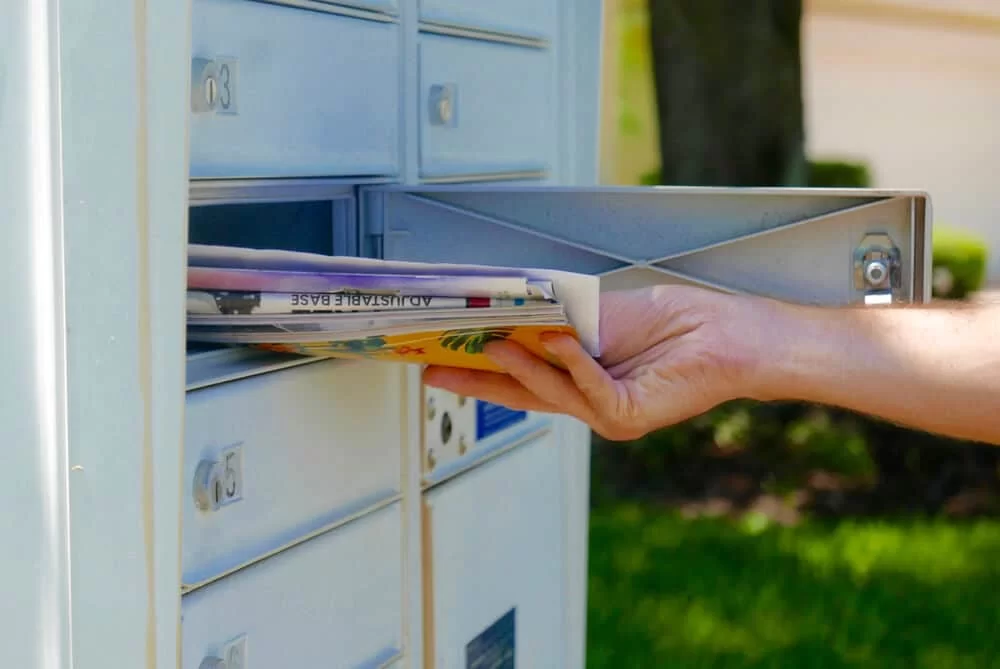Hand taking mail out of a mailbox