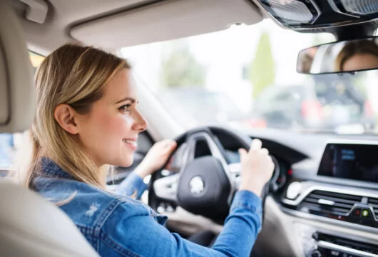 Young woman driving a car rented with cash only