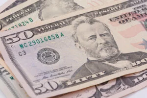 $50 bill resting on top of other bills after cashing a check