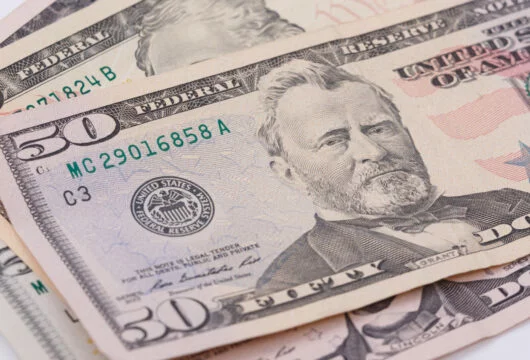 $50 bill resting on top of other bills after cashing a check