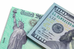 Government check and $100 bill