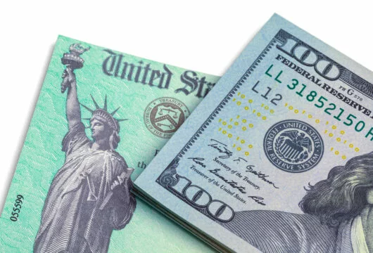 Government check and $100 bill