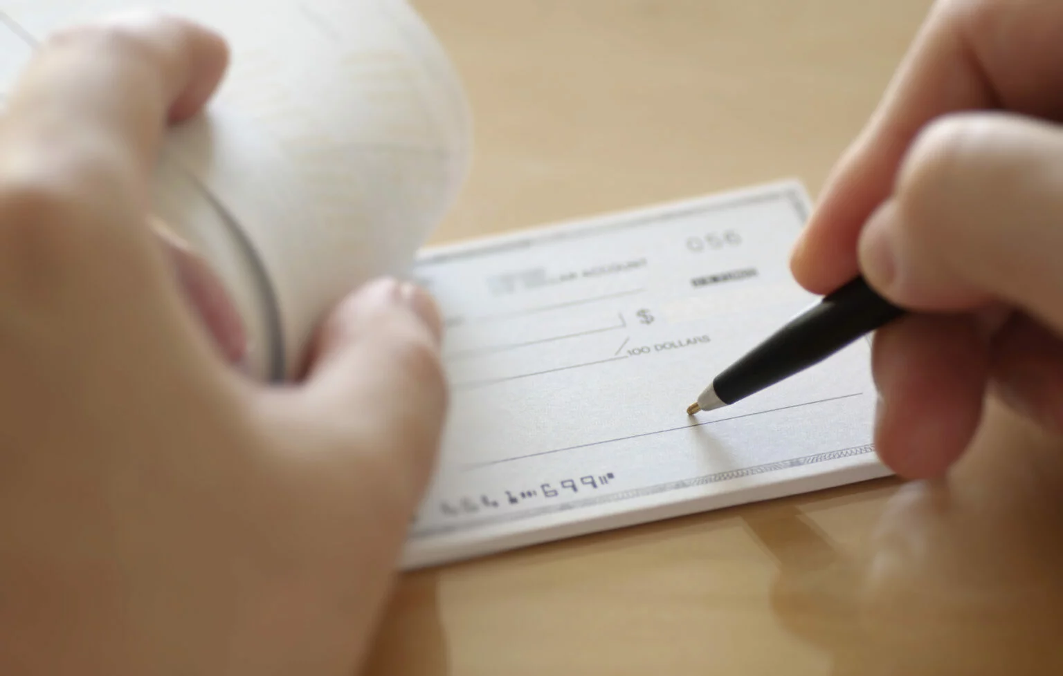 Close-up of a person filling out a personal check