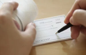 Close-up of a person filling out a personal check