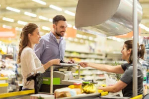 Couple in the checkout line at a grocery store like Tops Friendly Market