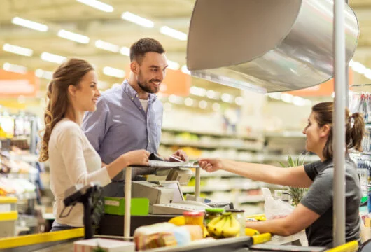 Couple in the checkout line at a grocery store like Tops Friendly Market