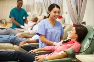 Medical technician assisting a plasma donor