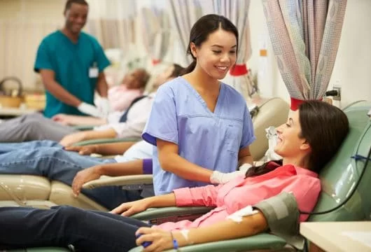 Medical technician assisting a plasma donor