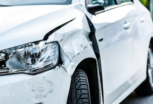 White rental car with damage from an accident