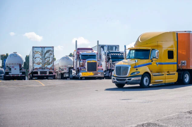 Yellow rig pulling into a truck stop parking lot to get a Comchek