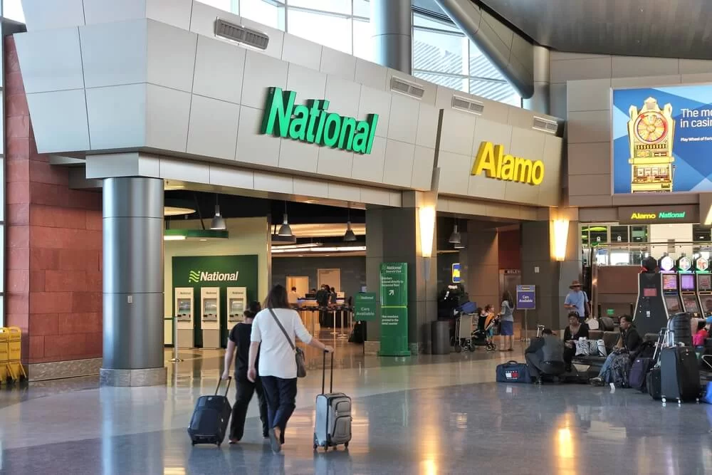person with luggage walking to a car rental airport location