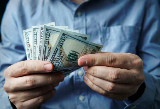 Close-up of man's hands counting cash after cashing a 401(k) check