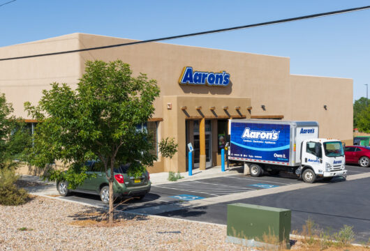 Exterior of an Aaron's store with an Aaron's delivery truck parked outside