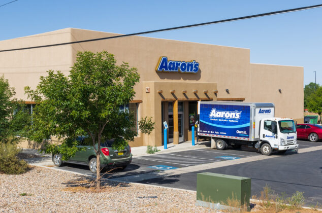Exterior of an Aaron's store with an Aaron's delivery truck parked outside