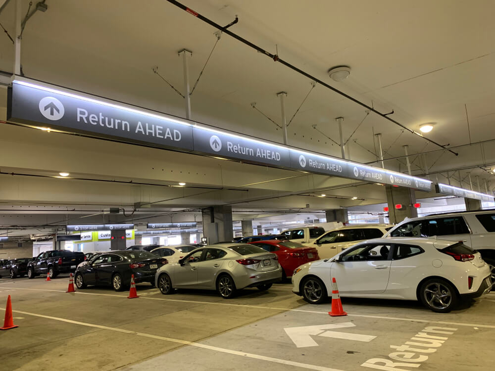 Parking garage with signs for car rental return ahead