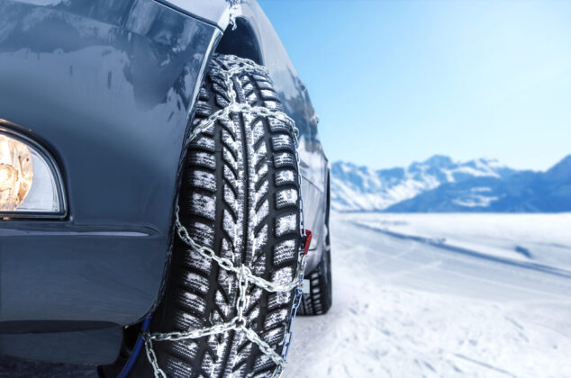 Close-up of a rental car tire with snow chains
