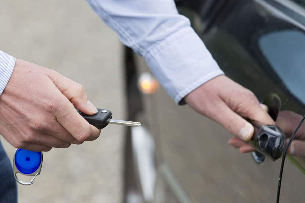 Man unlocking a by-the-hour rental car and opening the door