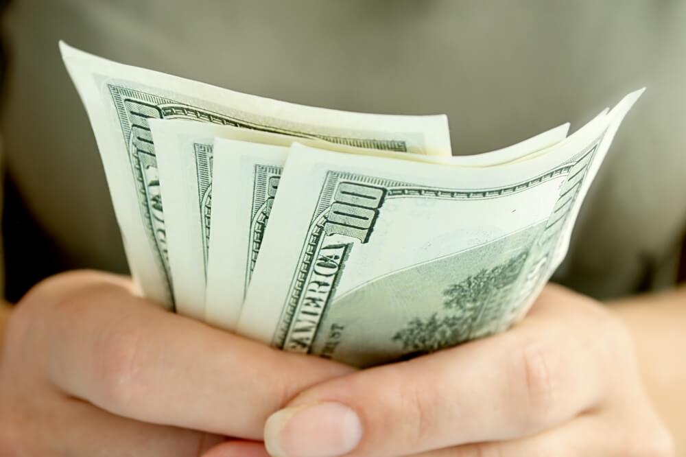 Woman's hands holding cash after cashing a check