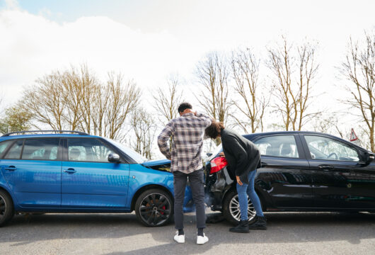 People inspecting their cars after a rear-ending accident
