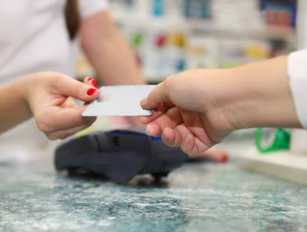 Customer handing a store credit card to the cashier at a store