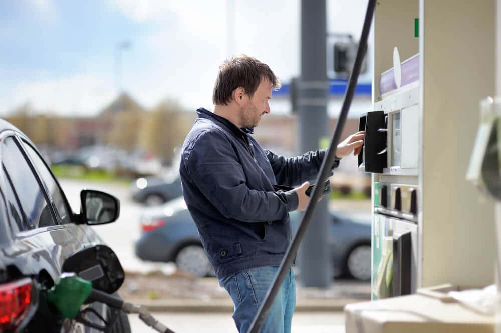 A man overdrafting at a gas station pump.