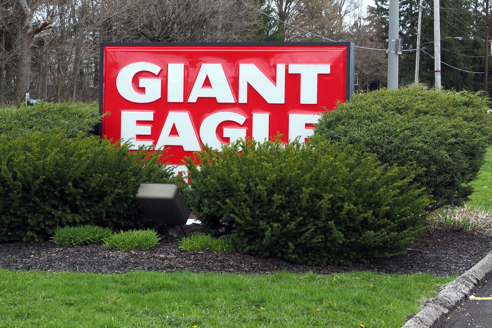 Logo sign partially obscured by shrubs outside of a Giant Eagle store