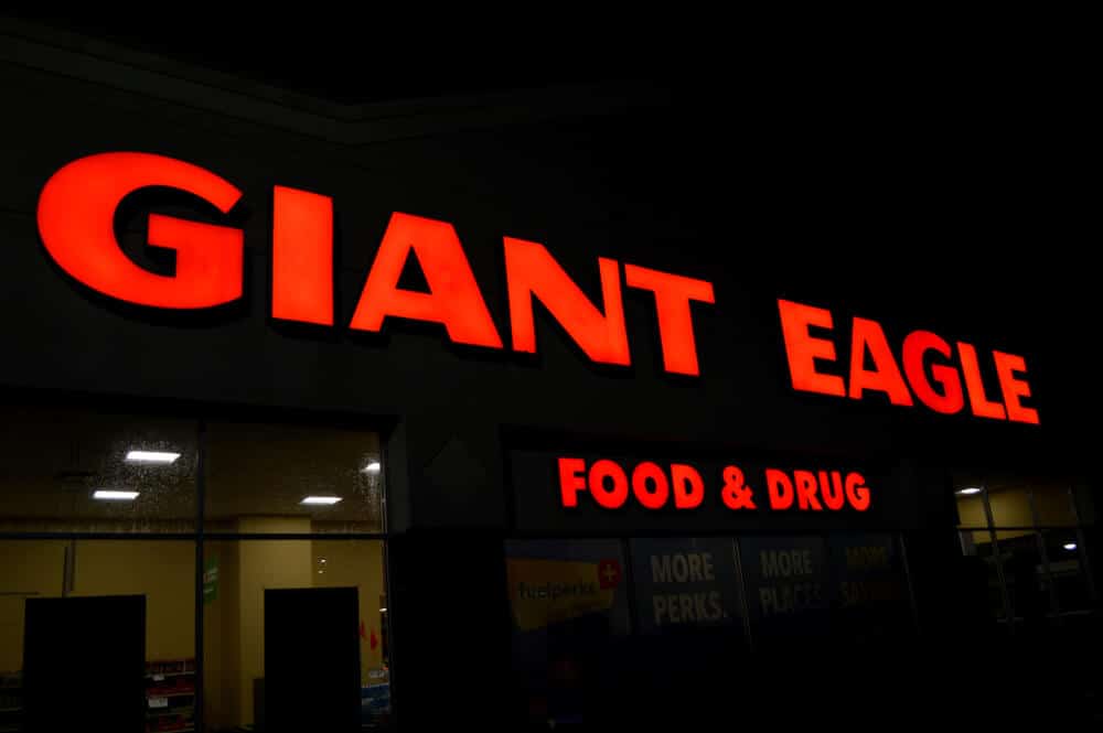 Neon sign lit in red on the outside of a Giant Eagle store at night