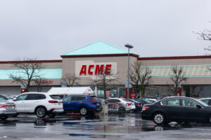 Exterior of an ACME Markets store and busy parking lot