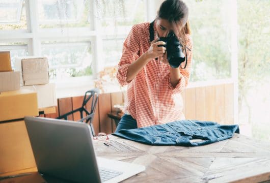 Woman taking a picture of a denim shirt to sell online