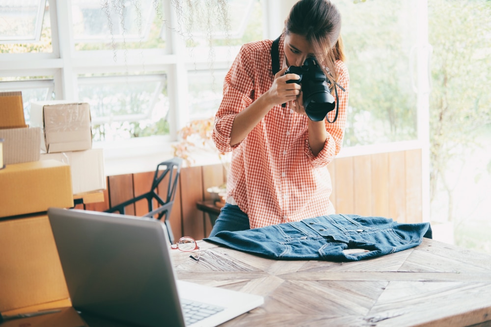 Woman taking a picture of a denim shirt to sell online