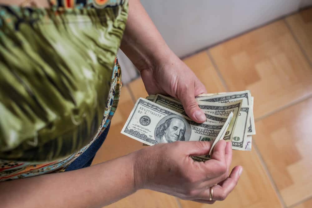Woman counting cash after cashing a money order