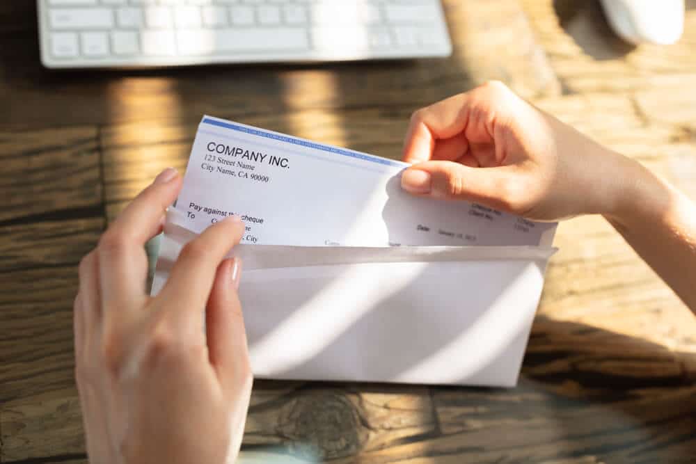 Woman removing an estate check from an envelope