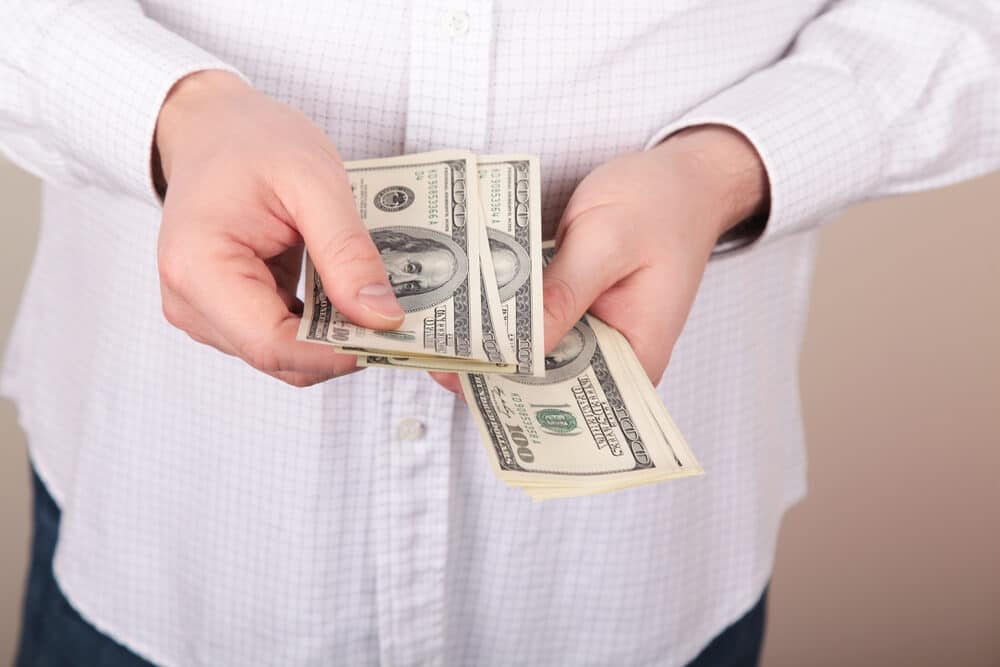 A man counting money after getting his refund back on his money order.