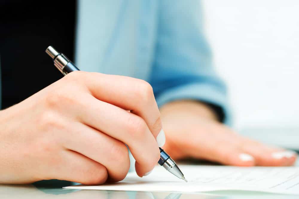 A woman signing over a check to someone else