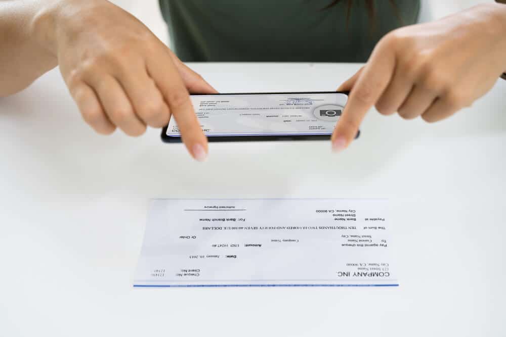 Woman using a smartphone to mobile deposit a check
