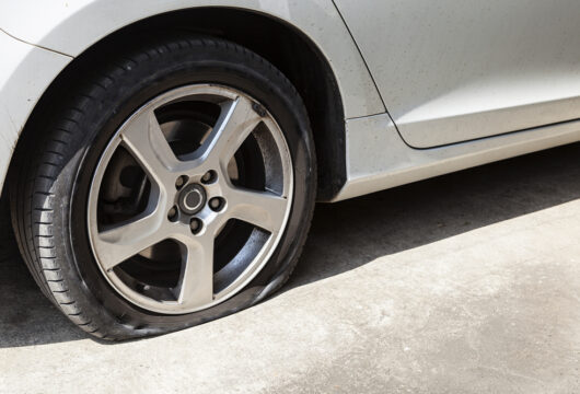 Close-up of a flat tire on a rental car