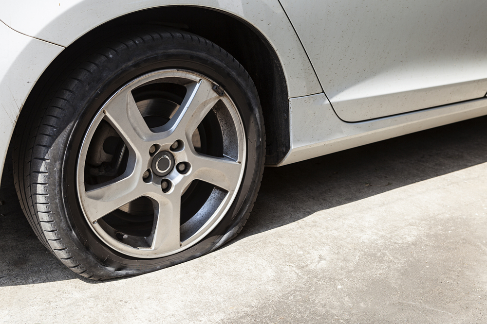 Close-up of a flat tire on a rental car