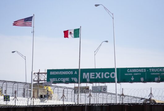 Mexican and American flags shown at a U.S.-Mexico border crossing