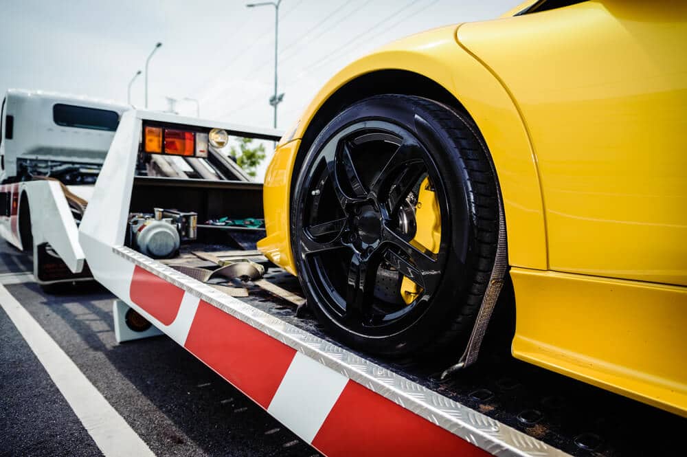 Sports car loaded onto a tow truck after repossession