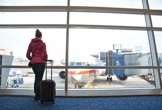 Woman standing in front of window at airport
