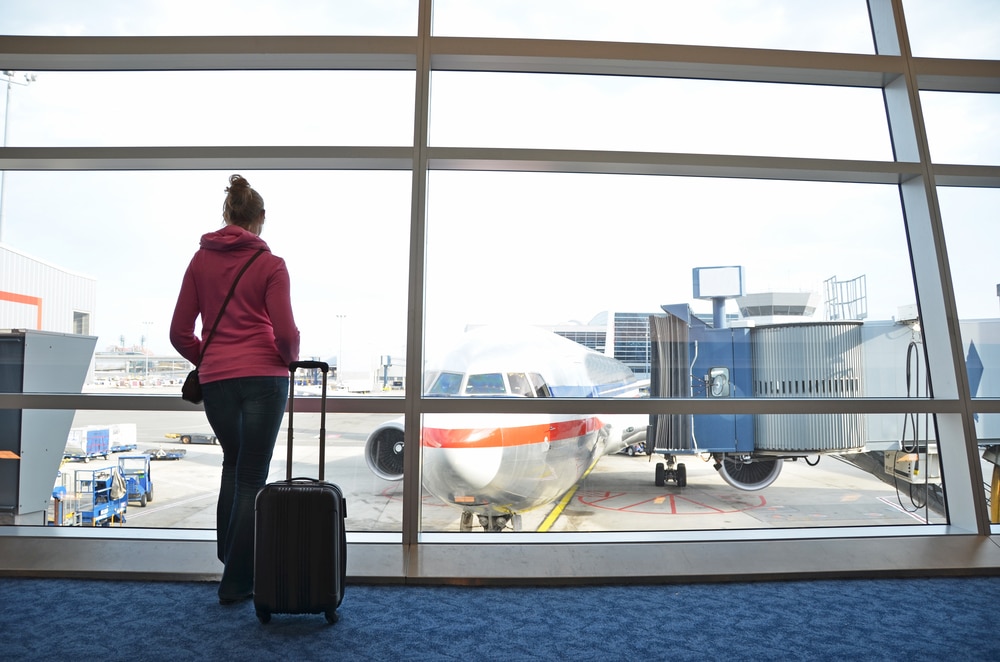 Woman standing in front of window at airport